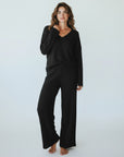 Silvorne black ribbed knit V-neck loungewear set with wide leg pants on a woman.