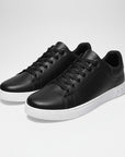 Silvorne men's black low-top sneakers with white soles. Smooth leather-look exterior, lace-up closure, and minimalist design.