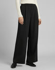 Silvorne women's black wide-leg trousers with elastic waistband and pleated detail, made from a flowing fabric.