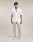 Silvorne men's white short sleeve button-up shirt with open-knit texture and camp collar, paired with light beige trousers.