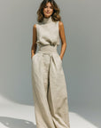 Silvorne beige linen tank top and wide-leg pants set with high neck and cinched waist.