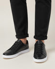 Silvorne black leather-look low top sneakers with white soles, laced front, and a minimalist design.