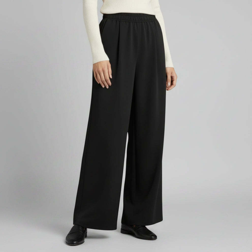Silvorne women's black wide-leg trousers with elastic waistband and pleated detail, made from a flowing fabric.