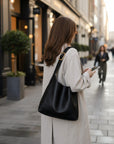 Silvorne Bolso negro de cuero suave con hebilla dorada y correa ajustable, estilo slouchy.