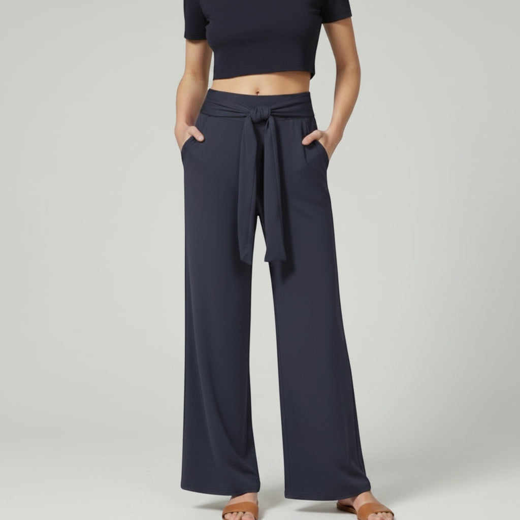 Silvorne navy blue wide-leg trousers with tied waistband and pockets, styled casually.