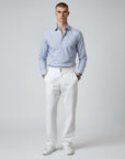 Silvorne men's white high-waist straight-leg trousers with double button closure and front pleats. Model wears with a blue striped shirt.